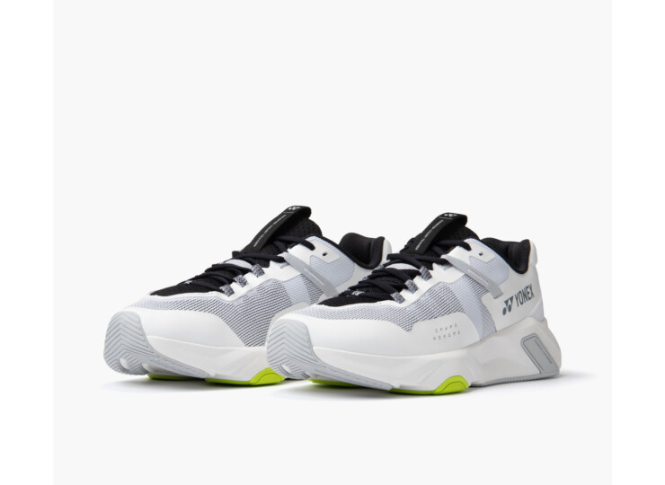 Pair of Yonex athletic sneakers in white and gray with black laces and lime-green accents.