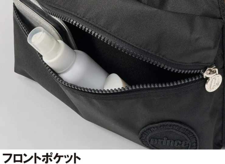 Front pocket of a black backpack with a spray bottle and a small bottle peeking out through the open zipper.