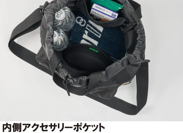 Open black shoulder bag showing an interior zip pocket and items: two water bottles, a towel, and small accessories for storage.