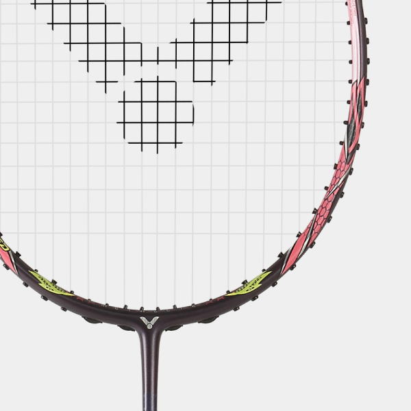 Close-up of a tennis racket head with white strings forming a geometric grid pattern and a pink/black frame visible along the rim
