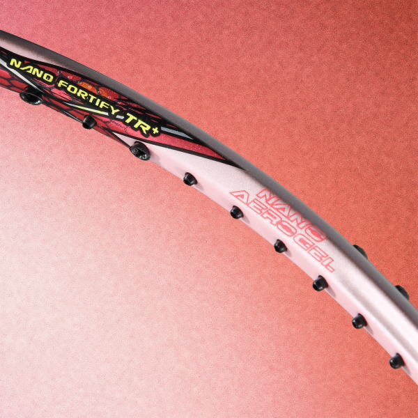 Close-up of a tennis racket frame showing branding: 'NANO FORTIFY-TR+' on a pink-white frame against a reddish background.