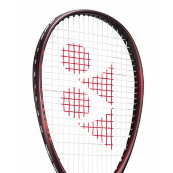 Close-up of a tennis racket head with red string patterns forming heart shapes in the strings.