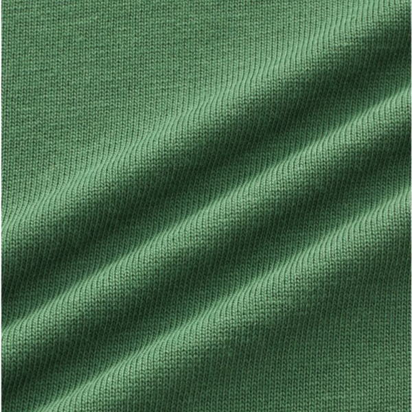 Close-up of green knitted fabric with diagonal folds and texture formed by interwoven threads.