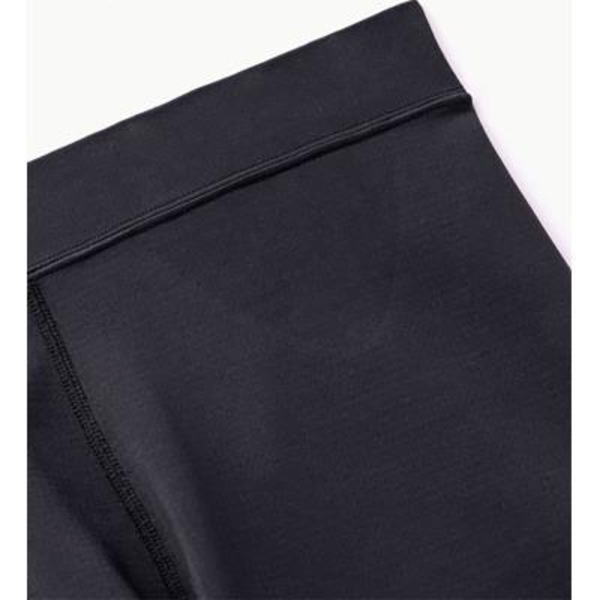 Close-up of black athletic fabric showing a waistband seam and flatlock stitching used in leggings or athletic wear