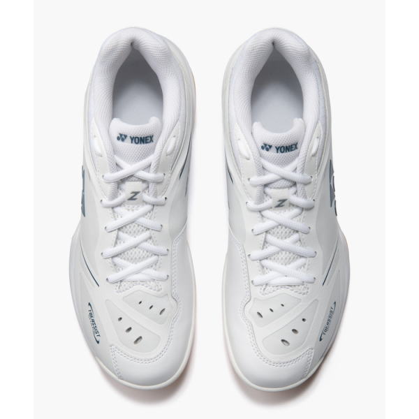 Pair of white Yonex tennis shoes viewed from above, laces tied, with blue Yonex logos on the sides.