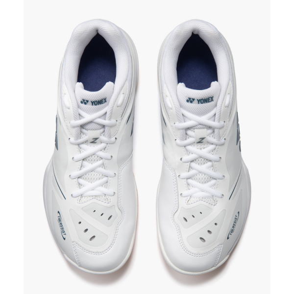 Pair of white Yonex athletic shoes viewed from above, laces tied, navy interior lining visible at the ankles