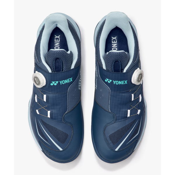 Top-down view of a pair of blue Yonex sports shoes with Velcro straps and padded collars.