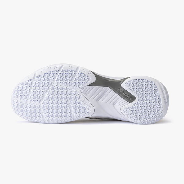 Bottom view of a white athletic shoe outsole with textured grip pattern and Yonex branding in the midfoot.