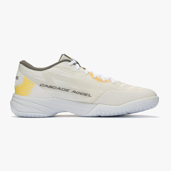 Cream-colored athletic shoe with white sole, white laces, and a yellow heel accent labeled Cascade Accel (side view).