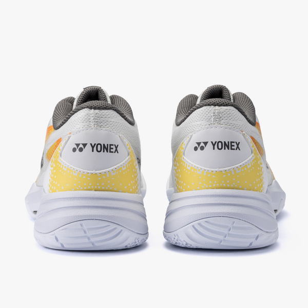 Pair of Yonex running shoes seen from behind, white with yellow accents and gray interior lining