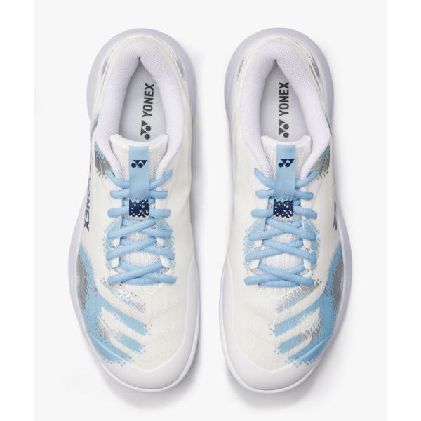 Top-down view of a pair of white athletic sneakers with light blue laces and blue accents; Yonex branding visible on the insoles.