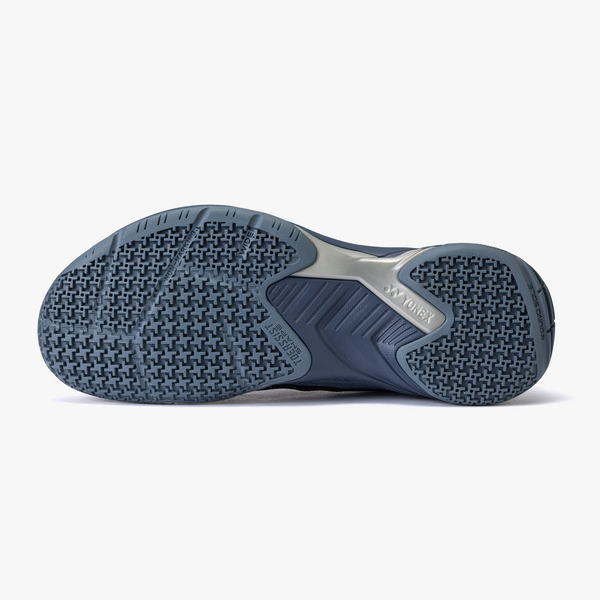 Bottom view of a blue athletic shoe sole with a textured, multi-directional tread and Yonex branding.