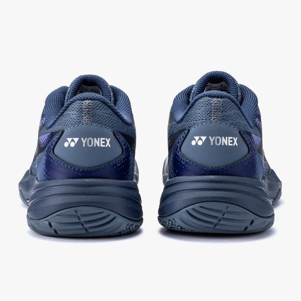 Pair of dark blue Yonex athletic shoes shown from behind, with logo visible on the heel