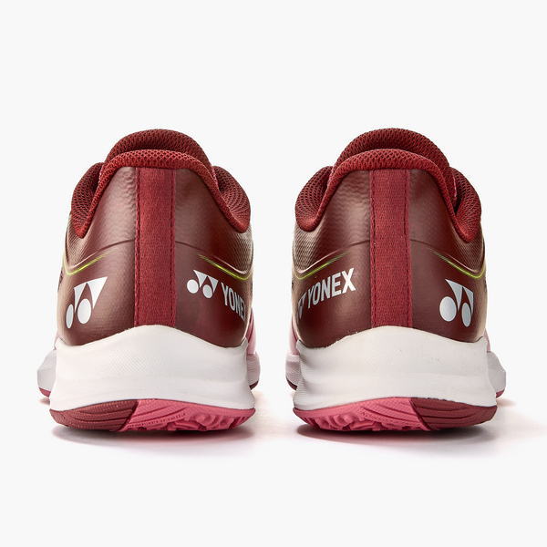 Rear view of two maroon Yonex athletic shoes with white midsoles and pink outsoles; Yonex logos visible on the back.