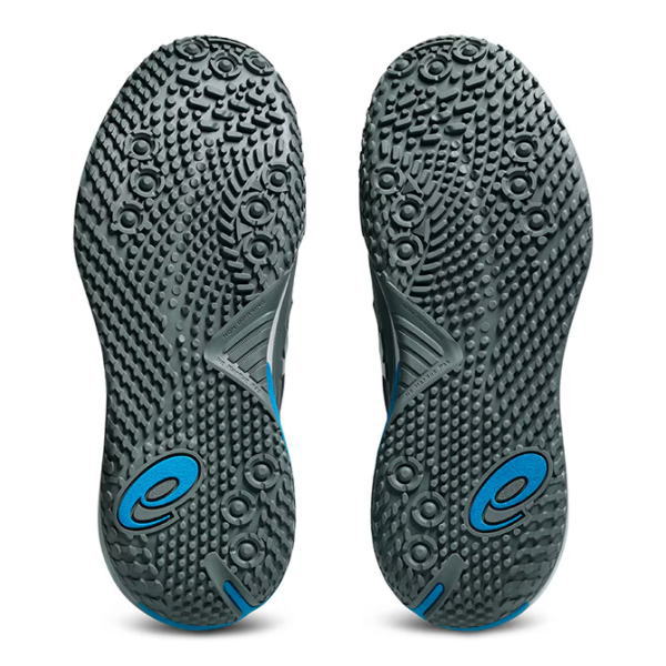 Bottom view of a pair of dark gray athletic shoes with textured, studded outsoles and blue accents.