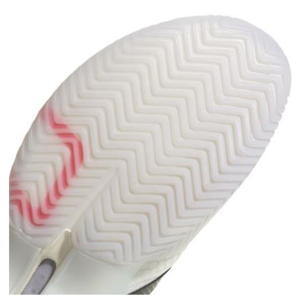 Bottom view of a white sneaker sole with a chevron/herringbone tread and a pink pressure-highlight area on the midsole edge.