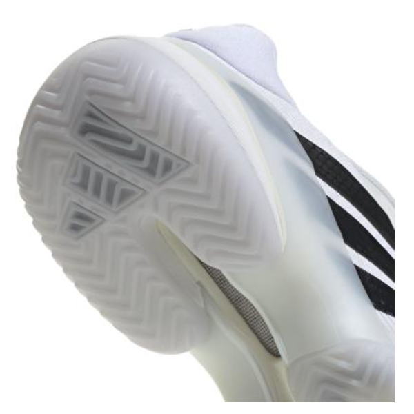 Close-up of a white sneaker sole showing zigzag and herringbone tread patterns