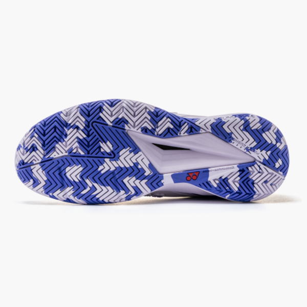 Bottom view of a blue and white zigzag outsole on a sport shoe with a Yonex logo nearby.